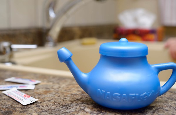 Neti pot and sinus rinse sitting on a counter top.