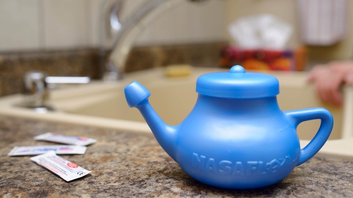 Neti pot and sinus rinse sitting on a counter top.